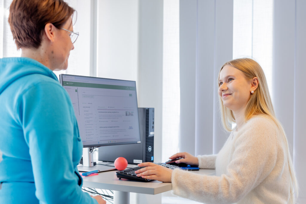 A young girl and an Ohjaamo employee sitting at a computer.