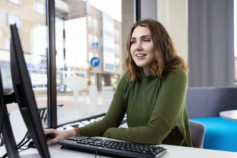 A woman is using a computer.