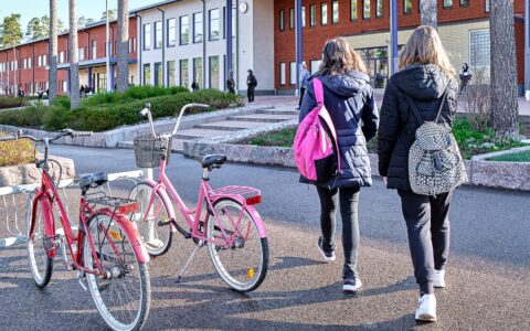 Kaksi opiskelijaa kävelee kohti koulurakennusta.
