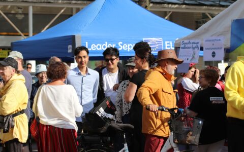 A group of people are having a discussion at a public event in Karhula Market Square.
